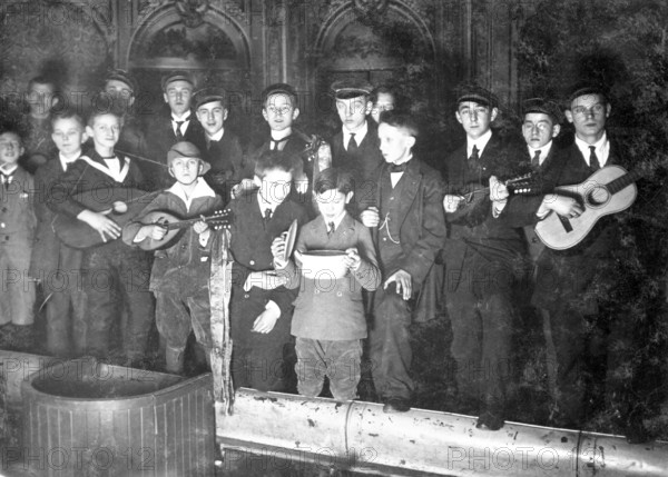 Boys in school uniform giving a performance, 1930s, Young men with guitars and mandolins, one