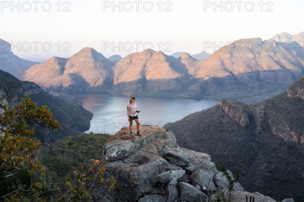 Hiker enjoying sunset at Blyde River Canyon, view of canyon with Blyde River in the evening light,