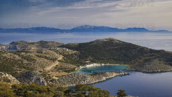 View of a coastal landscape with hilly vegetation and blue water, Holy Week, Bay of Panormitis,