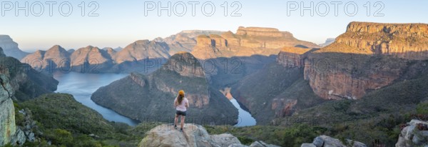 Hiker enjoying sunset at Blyde River Canyon with Three Rondawels peak, view of canyon with Blyde