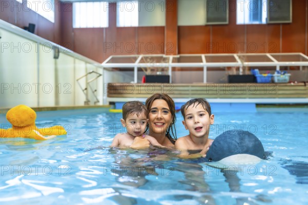Mother and children enjoying playful moments, laughing and splashing together in the swimming pool