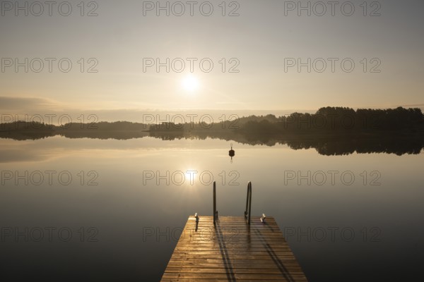 Wooden footbridge with ladder, sun reflected in the sea, morning mood, Kasnäsintie, Falkö Fjord,