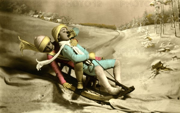 Two children sledding, 1930s, Two children in colourful winter clothing sledding in a snowy