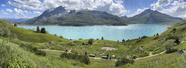 Panoramic view of Lac du Mont Cenis, in the foreground Alpine garden Jardin Alpin next to pass road