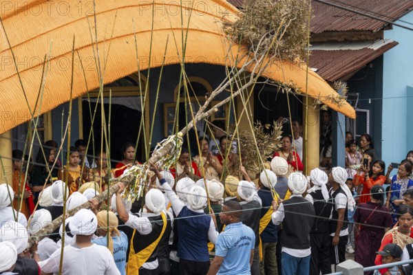 People from the Pnar community perform rituals as they using a tree to celebrate an event organised