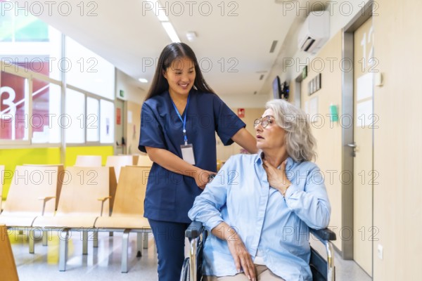 Young nurse supporting elderly woman experiencing respiratory problems in wheelchair, providing