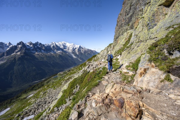 Mountaineer on hiking trail, mountain panorama with glaciated mountain peaks, Aiguille du Midi and