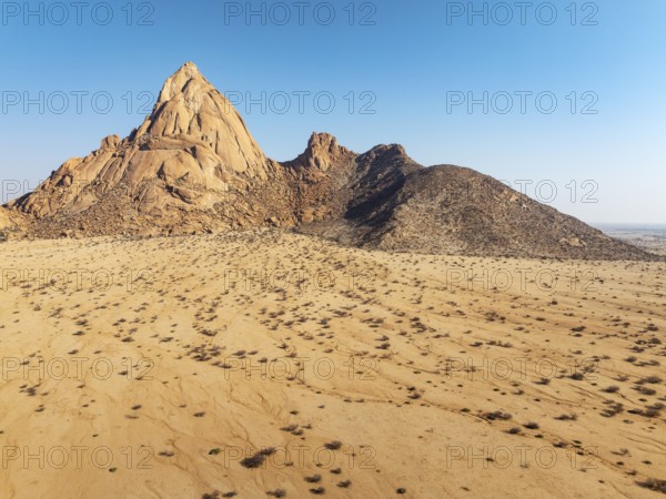 The isolated Spitzkoppe mountain (1728 m) majestically rises above the surrounding desert plains.