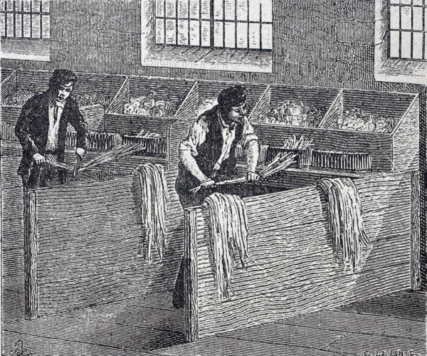 Textile industry, spinning mill, men working on a hand hackle, tool made of wood or metal with