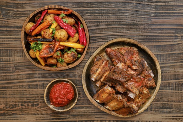 Succulent short beef ribs roasted in the oven served alongside a medley of grilled vegetables and a
