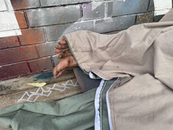 Homeless man sleeping on a bench, Yorkstrasse corner Möckernstrasse, Friedrichshain-Kreuzberg