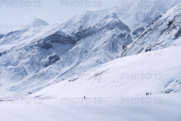 People walking through the snow, in the high mountains, Himalayas, Spitital, Kaza, Himachal