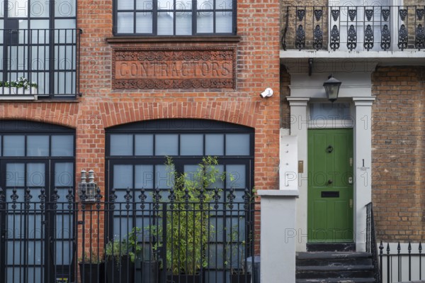 Historic brick building labelled Contractors, green door, Kensington, London, England, United