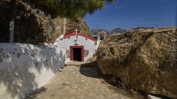 Legend, crab, shell fisherman, chapel with red roof and sea view on a rocky coast, in natural and