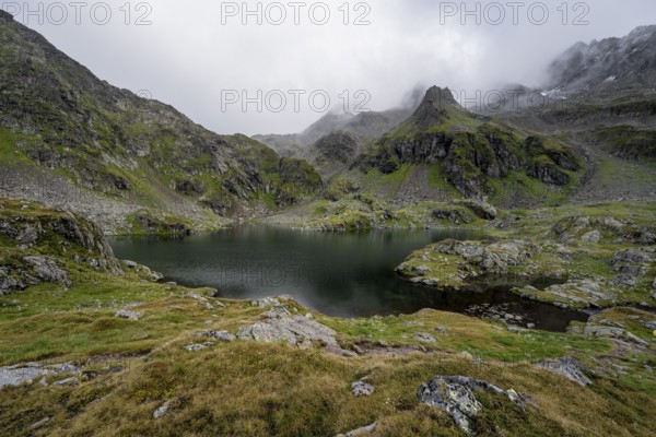 Mountain lake Kreuzsee, cloudy mountain peaks, Schober group, Hohe Tauern National Park, Carinthia,