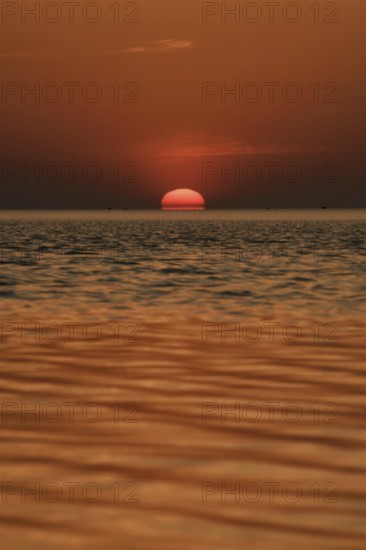 When the red sun sinks into the sea... Cuxhaven, North Sea, sunset in calm weather, glowing red