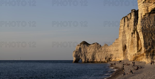 People on the beach, pebble beach, rock arch Falaise or Porte d'Amont, Étretat, sea, steep coast,