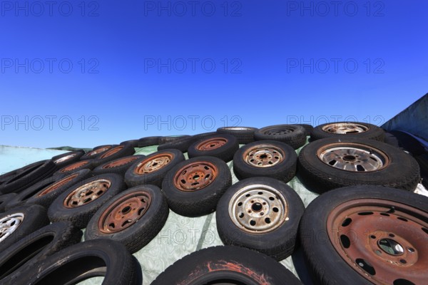 Old wheels, rims and tyres, used here to weigh down the cover of an agricultural silo