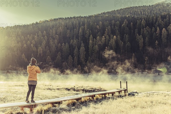 Young woman at Lake Staz near Sankt Moritz in the Engadine in Switzerland. Morning atmosphere with