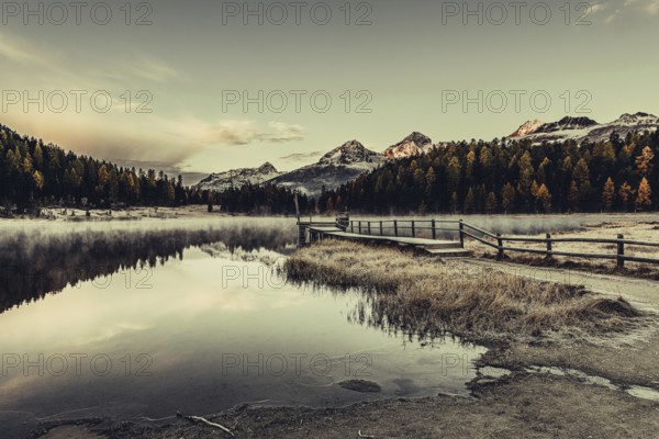Lake Staz near Sankt Moritz in the Engadin in Switzerland. Morning atmosphere with fog in autumn.