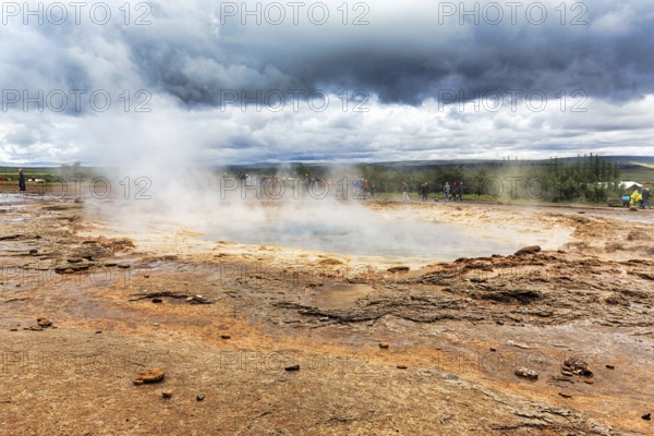 Steaming Strokkur, tourists waiting for eruption, high temperature area Haukadalur, tourist