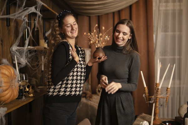 Two friends enjoy each others company as they prepare for an autumn celebration. They are