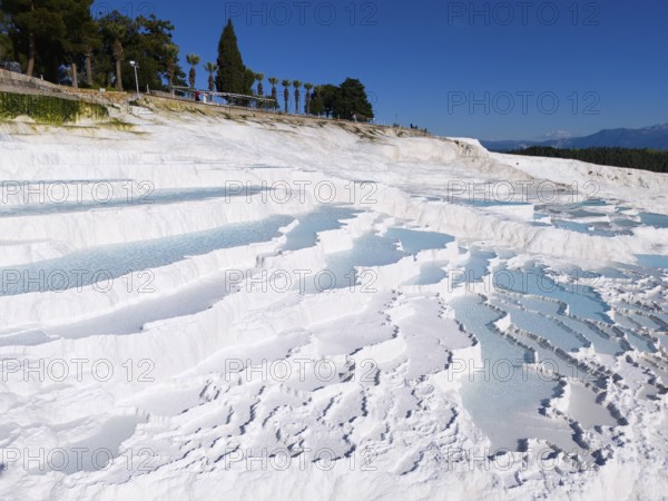 Cascading white terraces with turquoise water against a blue sky, aerial view, sinter terraces,