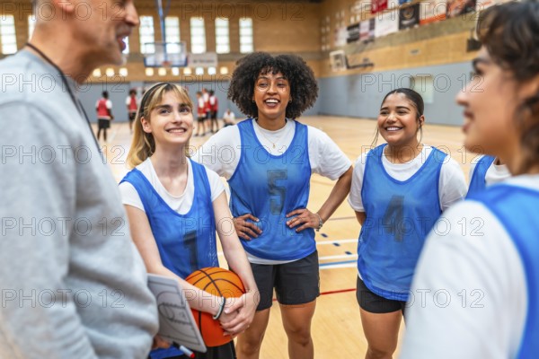 Happy multi ethnic female basketball players listening to coach instructions during training in a