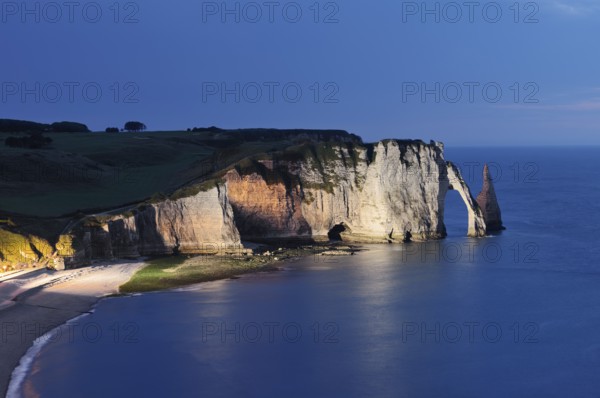 Cliffs with the Falaise d'Aval rock gate and the Aiguille d'Etretat rock needle at night, Etretat,