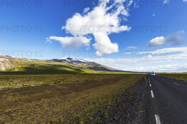 Tarmac road through barren volcanic landscape with a view of the snow-covered Snæfellsjökull