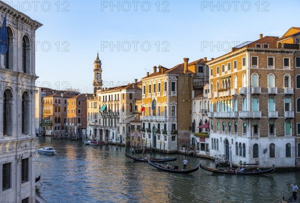 View of the Grand Canal with gondoliers at sunset, picturesque evening mood with palazzos on the