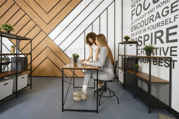 Two women are collaborating on a project in a stylish, modern office designed for a startup focused