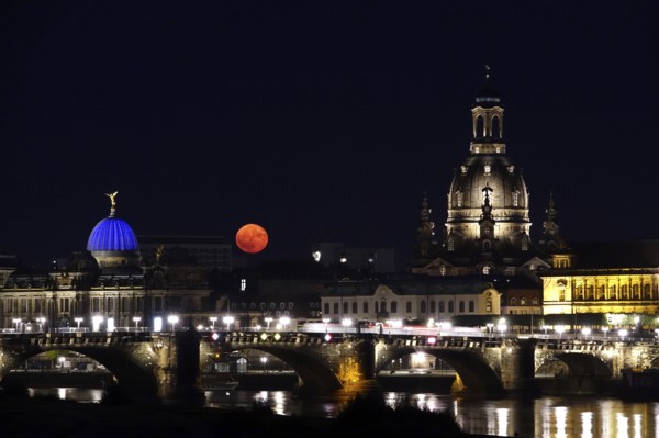 Glowing strawberry moon on 11 June 2025 over the Augustus Bridge in Dresden, between the