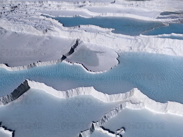 Detailed view of the limestone sinter terraces with turquoise-coloured water in Pamukkale, aerial