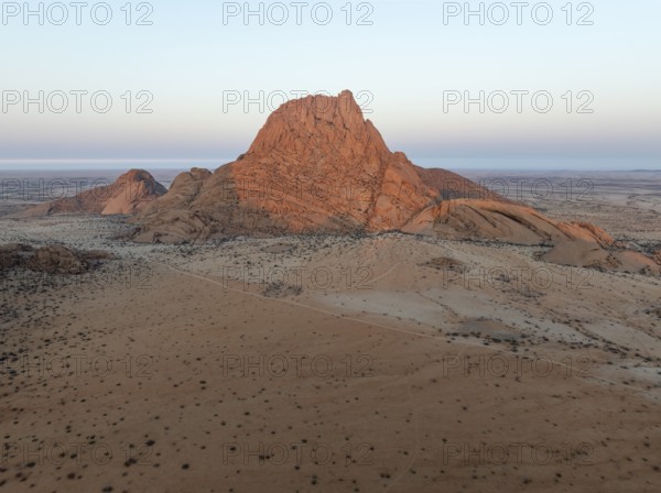 The isolated Spitzkoppe mountain (1728 m) majestically rises above the surrounding desert plains.