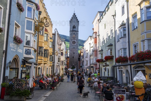 Old town, colourful houses in the main street, Zwölferturm tower at the back, old town, Sterzing,