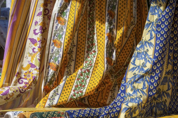 Various decorative fabrics with floral patterns in yellow and blue, typical of Provence, France