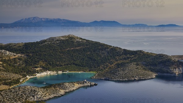 Coastal landscape with hills and blue water under a clear sky, Holy Week, Panormitis Bay,