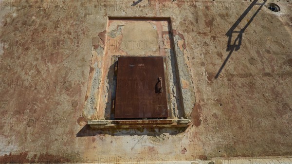 Lost Place, Locked rusty door in a weathered wall under summer light, Radio Station, WW2, Agios