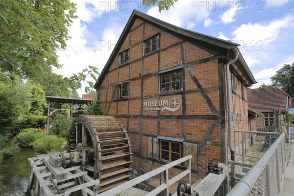 Grinding mill with brick building and water wheel, mill wheel, wooden construction, inscription,