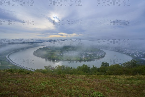 River bend under a cloudy sky and enveloping fog, gentle hills define the scenery, summer, Rhine