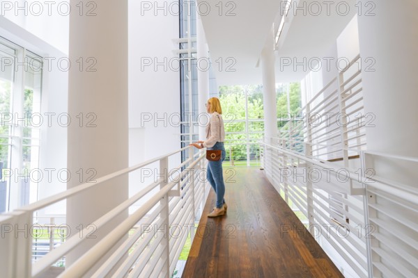 A woman stands in a modern, light-flooded interior with a wooden floor, Frieder Burda Museum, Baden