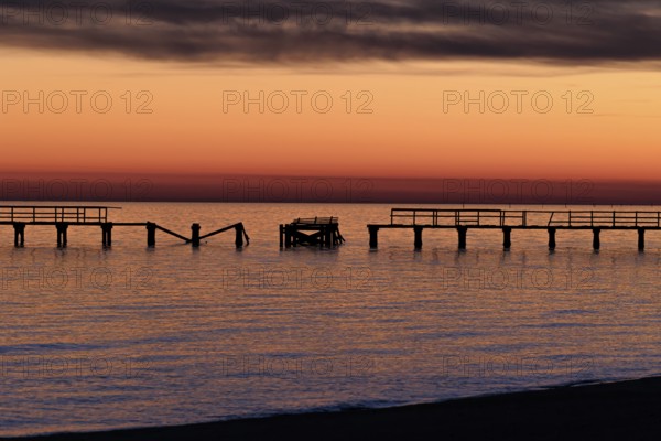 Sunset behind dilapidated fishing pier damaged by hurricanes on the Mississippi Gulf Coast in Long