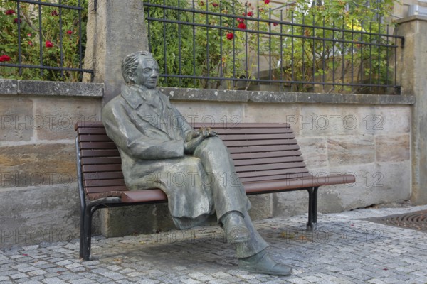 Johann Wolfgang von Goethe by Klaus Gutting sitting on the bench, bronze sculpture, looking, arms,