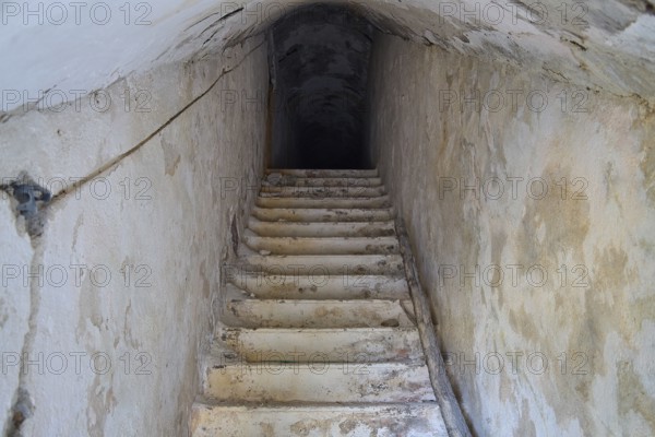 An old, narrow staircase leading deep into the darkness of an underground passage, Lost Place, Lago