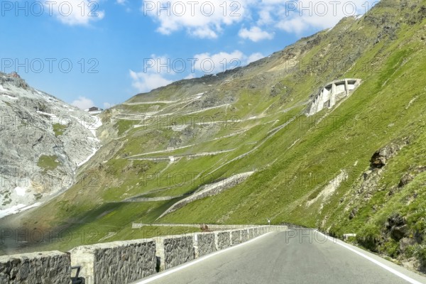 View of east ramp ascent to descent from Alpine pass Stelvio Stilfserjoch mountain road above tree