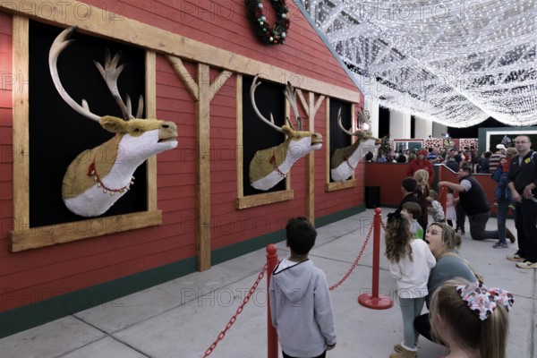 Children listen to animatronic reindeer inside the Barksdale Pavilion during the Harbor Lights