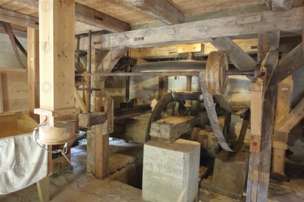 Interior view of mill, wooden construction, wooden beams, wheels, belt, drive wheel, flywheel,