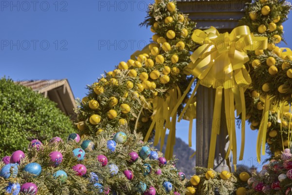 Easter fountain, Easter decoration, blown out coloured Easter eggs, trees, historical buildings,