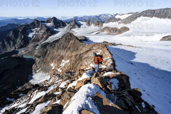 Mountaineer on a rocky ridge on the Wilder Freiger summit, behind him Signal summit and Becher